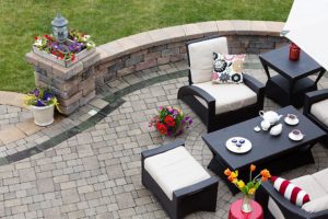 Residential home in Springfield, IL with a freshly paved patio that has a pattern in grey and black bricks with a black and white furniture set.